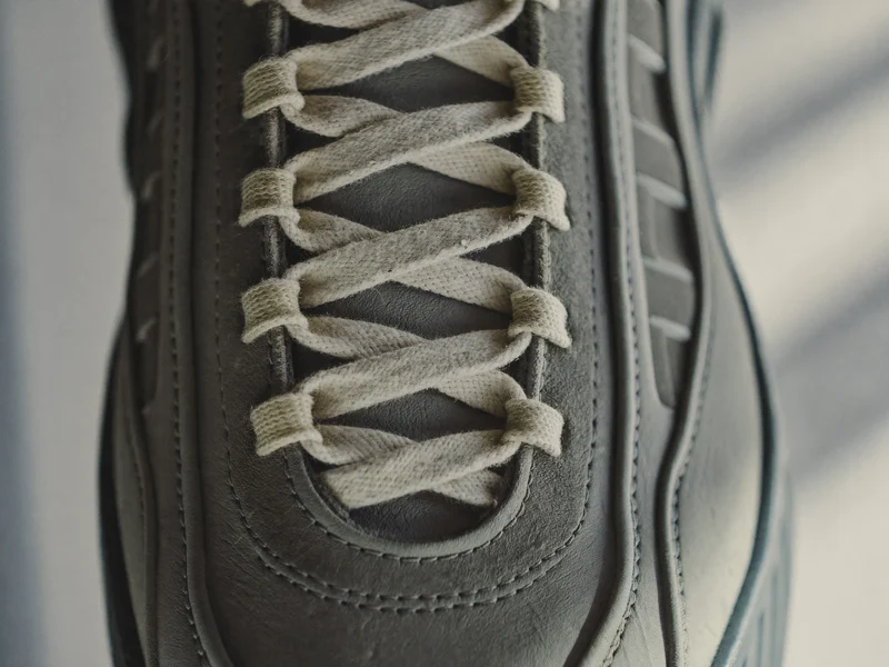 Nahaufnahme von Lederpaneel, Gummisohlenkante und Schnürsenkeln eines Sneakers